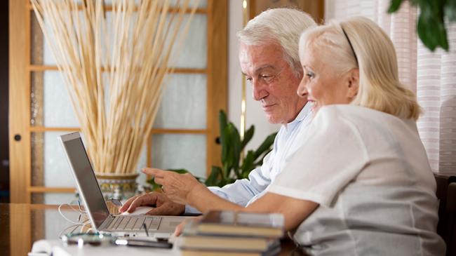 Older couple interacting with a laptop
