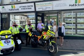Photo shows: Staff at Hall & Scott Estate Agents outside the Ottery St Mary branch with Devon Freewheelers volunteers.