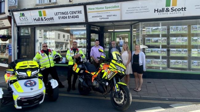 Photo shows: Staff at Hall & Scott Estate Agents outside the Ottery St Mary branch with Devon Freewheelers volunteers.
